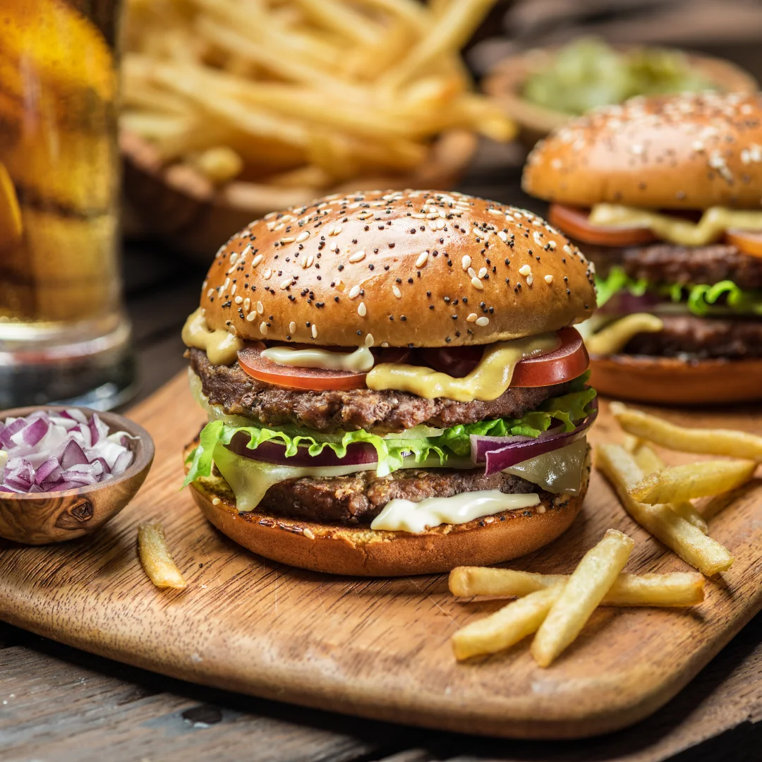 Primo piano di un hamburger gourmet a doppio strato con patatine fritte