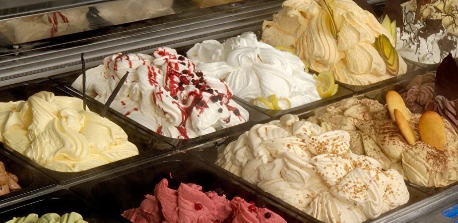 Vaschette di gelato artigianale di diversi gusti in vetrina refrigerata