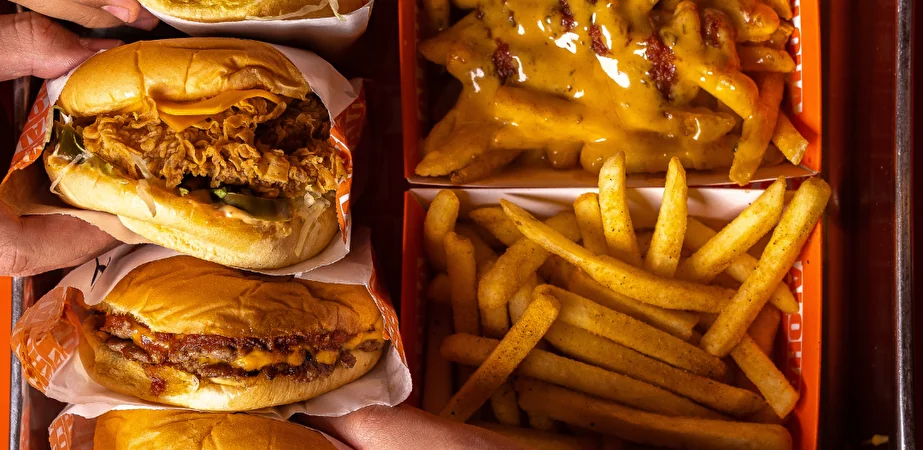 Hamburger e patatine con formaggio fuso confezionati in contenitori da asporto