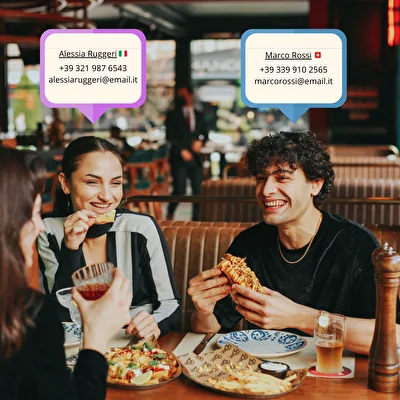 Due clienti a tavola con sopra le schede contatto (nome, telefono, email) raccolte per il marketing mirato